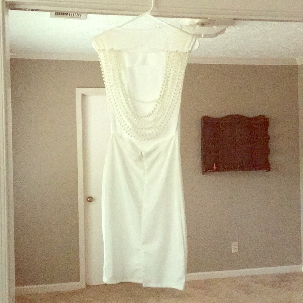 White dress with back draped with pearls.